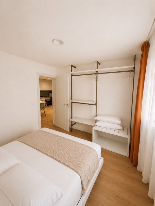 Schlafzimmer des Apartments Fly High in Morro Jable mit Queensize-Bett, Metallregalen und Kuchenzugang