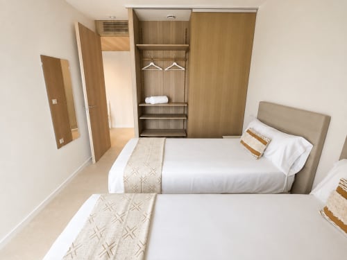 Moderna habitación del apartamento Holibai en Sabaris con camas gemelas, armario empotrado y mobiliario contemporáneo