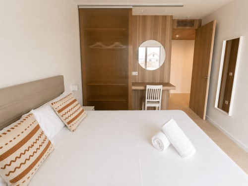 Dormitorio moderno con muebles de madera y ventana panorámica, apartamento Holibai en Sabarís cerca de Playa Ladeira