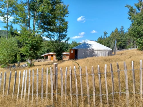 Hébergement en yourte à La Yourte Un Autre Monde au Hohwald avec clôture en bois et vue sur les montagnes boisées