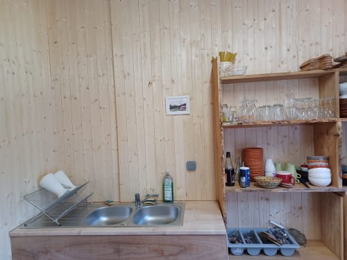 Petite kitchenette équipée dans la Yourte SOUSLIK à La Yourte Un Autre Monde, Le Hohwald, avec murs en bois, évier, rangements et coin repas