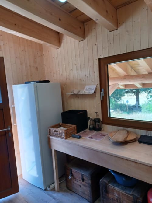 Intérieur douillet de yourte avec poutres en bois, kitchenette et vue montagne à La Yourte Un Autre Monde