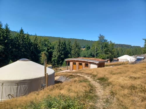 Hébergement en yourte à La Yourte Un Autre Monde au Hohwald avec bâtiment en bois et vue sur les forêts de montagne