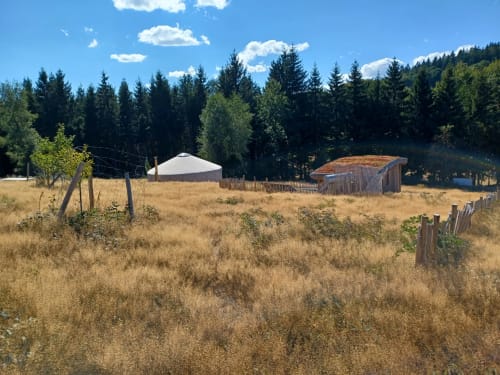Yourte TAKHI glamping à La Yourte Un Autre Monde au Hohwald avec vue sur les montagnes boisées et structures rustiques