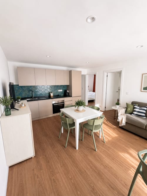 Moderne Küche und Wohnbereich im Apartment Fly High in Morro Jable mit Meerblick, weiße Schränke, türkisfarbene Rückwand, Essbereich