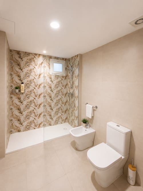 Modernes Badezimmer im Hotel Fly High mit begehbarer Dusche, Toilette, Bidet und blattgemusterten Fliesenwänden in Morro Jable