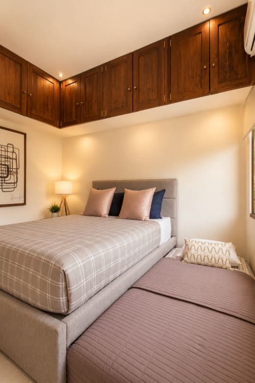 Stylish master bedroom at Casa Javi with dark wood cabinetry, neutral bedding, and ocean view access in Isla Mujeres.