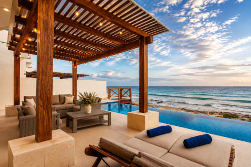 Oceanfront Casa Javi cottage in Isla Mujeres with infinity pool, wooden pergola, and beachfront lounge area overlooking