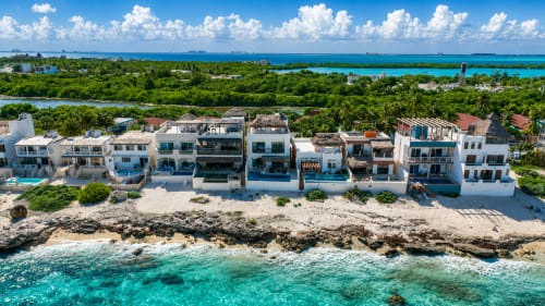 Oceanfront beachfront cottages in Isla Mujeres with turquoise Caribbean waters, white sandy beach, and lush tropical