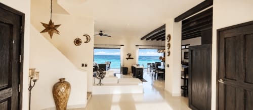 Modern oceanfront cottage in Isla Mujeres with beachfront view, open-concept living area with dark beams and turquoise sea