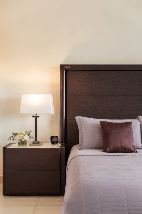 Modern bedroom at Casa Javi Ocean Front Isla Mujeres with dark wood bed, nightstand, lamp, and decorative pillows