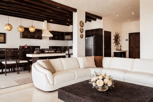 Modern oceanfront cottage living room at Casa Javi in Isla Mujeres with cream sectional sofa and dark wood kitchen