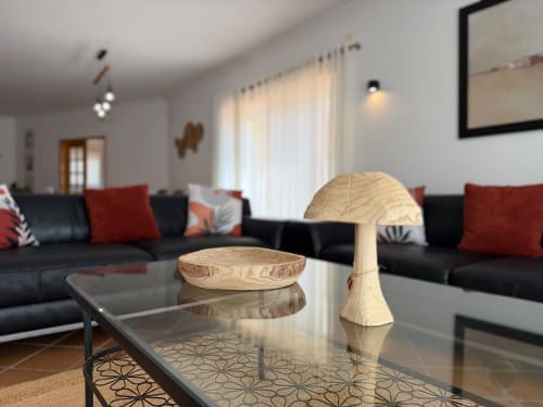 Moderna sala de estar da casa de vila Be SilverCoast com sofá preto, acentos vermelhos, decoração em madeira e vista para o mar
