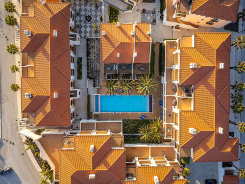 Vista aérea do hotel Be SilverCoast em Serra D'El Rei com casarões de telhado em barro ao redor de uma piscina compartilhada