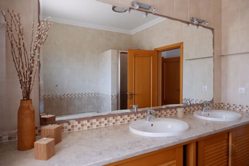 Banheiro luxuoso com pias duplas, bancada de mármore e chuveiro aberto no hotel Be SilverCoast, Serra D'El Rei