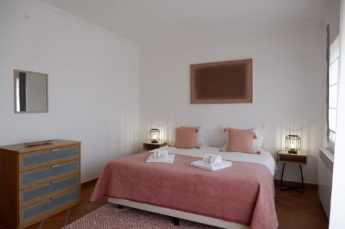 Quarto moderno Be SilverCoast, Serra D'El Rei com roupa de cama rosa, móveis de madeira, espelhos e design de casa de praia