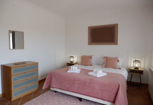 Quarto espaçoso na casa de vila Be SilverCoast com cama queen, roupa de cama rosa, móveis de madeira e área de estar em Serra D'El