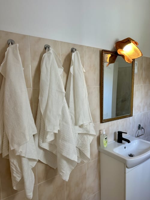 Salle de bain de Villas Simone Porto Santo avec serviettes blanches, miroir éclairé et lavabo blanc