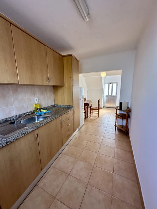 Cuisine moderne aux armoires en bois, plan de travail en granit et carrelage en terre cuite aux Villas Simone Porto Santo