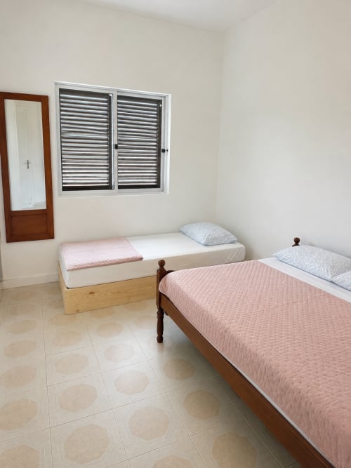 Quarto claro com duas camas e estruturas de madeira nos apartamentos Villas Simone Porto Santo