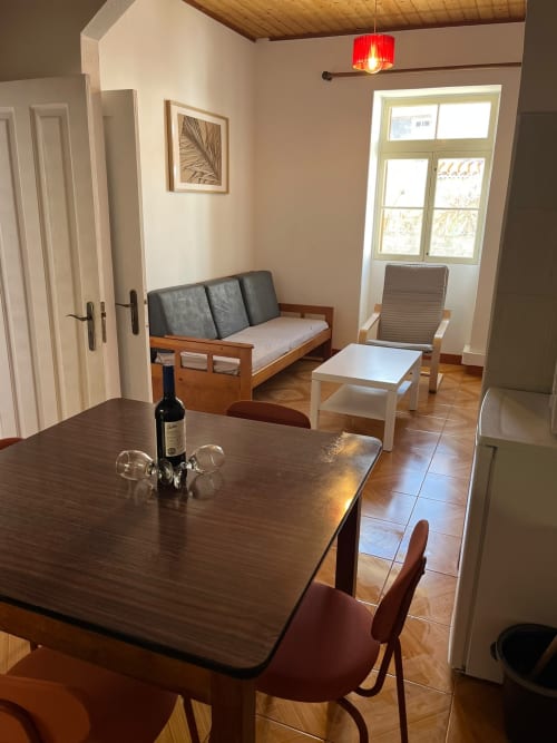 Área de estar do apartamento Casa do Taxista com mesa de jantar, sofá e acesso ao terraço-jardim em Porto Santo