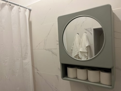 Espelho de banheiro moderno com prateleira de armazenamento e toalhas nos apartamentos Villas Simone Porto Santo