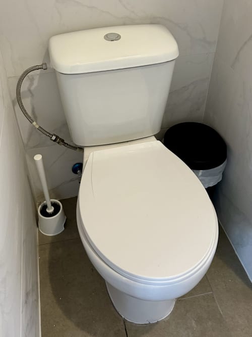 Vaso sanitário branco com a tampa fechada na casa de banho partilhada do apartamento Casa do Taxista, Porto Santo Portugal