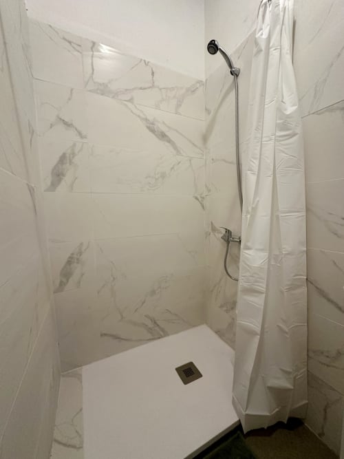 Chuveiro moderno tipo walk-in com azulejos com efeito mármore e chuveiro tipo chuva no apartamento Casa do Taxista, Porto Santo