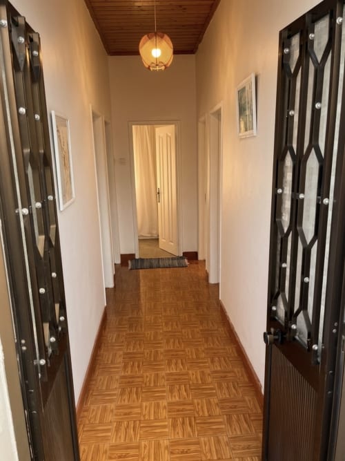 Corredor do apartamento Casa do Taxista em Villas Simone Porto Santo com pisos de madeira, portas pretas e iluminação pendente