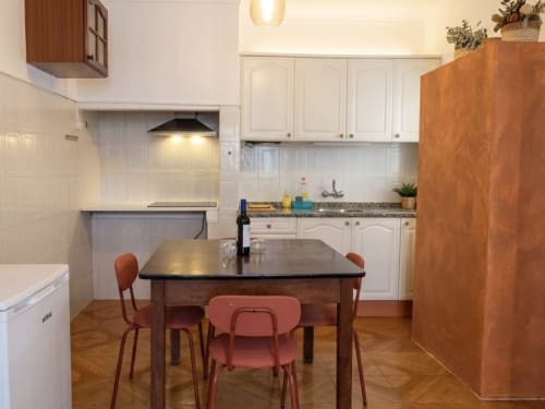 Cozinha moderna e área de refeições no apartamento Casa do Taxista nas Villas Simone Porto Santo com mesa de madeira, cadeiras vermelhas e