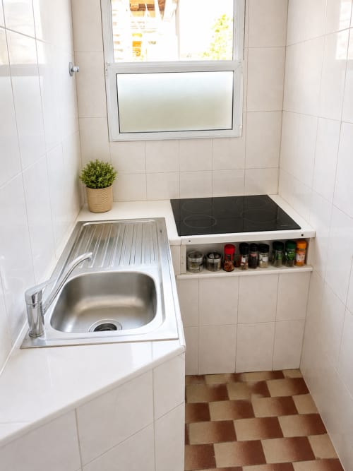 Compact kitchen in Family Loft at Villas Simone Porto Santo with sink, electric cooktop, and spice storage shelf
