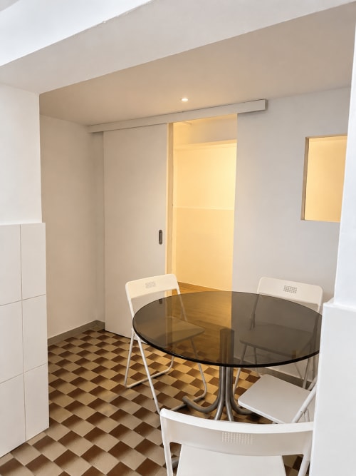 Family Loft dining area at Villas Simone Porto Santo with round table, white chairs, and geometric floor