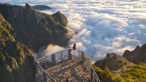Mulher em miradouro de montanha acima das nuvens no Refúgio Norte Madeira, Portugal