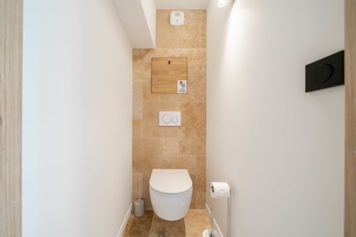 Modern toilet room in villa near Cannes with beige tile walls and white fixtures