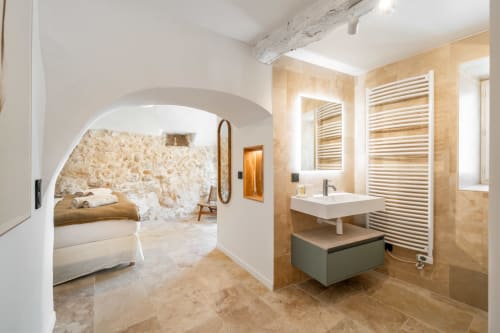 Modern luxury villa bathroom in Grasse with heated towel rack, floating vanity sink, and en-suite bedroom featuring stone
