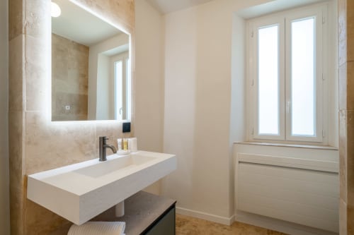 Modern bathroom in Villa M de Mas with illuminated mirror, white sink, and French doors at M Résidences in Grasse
