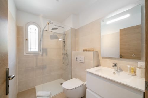 Modern bathroom with walk-in shower, sink, toilet and mirror at M Résidences villa in Grasse