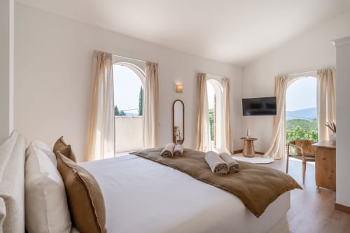 Bright bedroom in luxury villa near Cannes with arched doors, mountain views, and terrace access at M Résidences Grasse