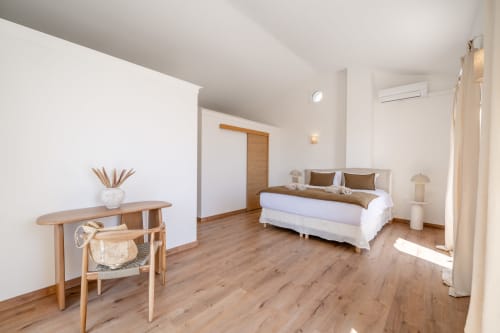 Modern bedroom in Villa M de Mas-Piscine, Grasse with wooden furniture, white bedding, and air conditioning