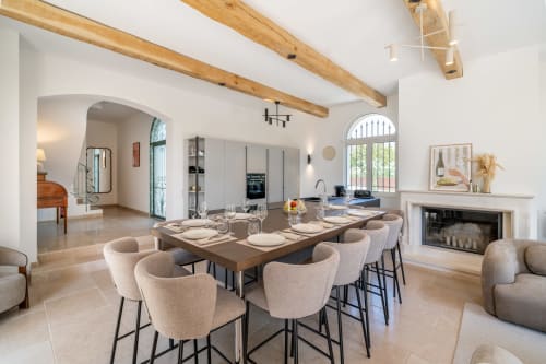 Modern villa dining room in Grasse with wood beams, fireplace, and seating for 10 at Mas-Piscine resort