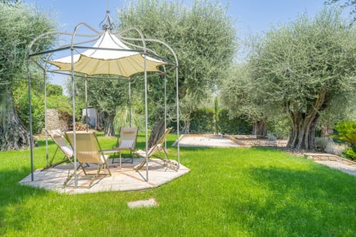 Elegant garden gazebo with seating at Villa M de Mas in Grasse, surrounded by mature olive trees and manicured lawn