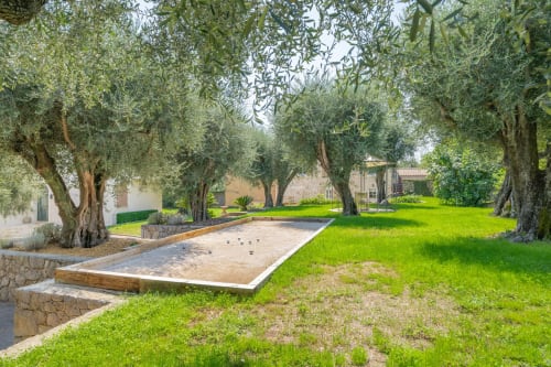 Olive tree-lined garden with bocce court at Villa M de Mas in Grasse, France