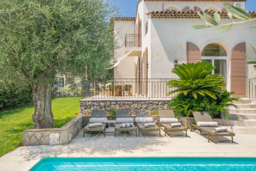 Luxury villa in Grasse with private pool, lounge chairs, olive tree, Mediterranean architecture, and manicured garden
