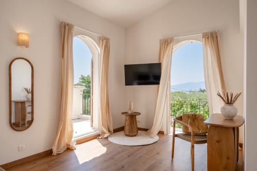 Luxurious hotel suite at M Résidences with panoramic windows, modern furnishings, and mountain views