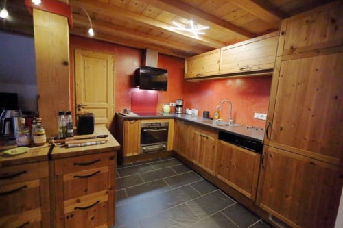 Cocina de madera en la casa rural Le Grand ValOmbre en Le ValOmbré, Saint-Pierre-de-Chartreuse, con paredes rojas y electrodomésticos modernos