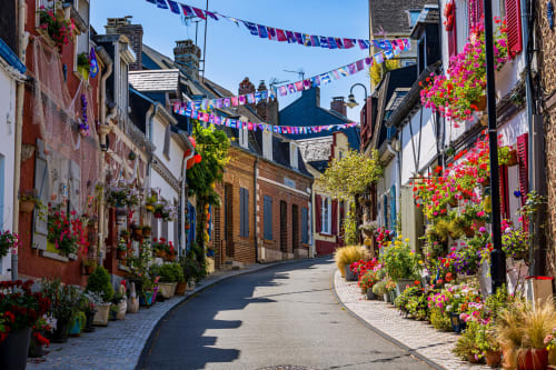 Charmante rue pavée de Mons-Boubert décorée de fleurs colorées et de guirlandes festives à la Maison d'hôtes du château de Mons Boubert
