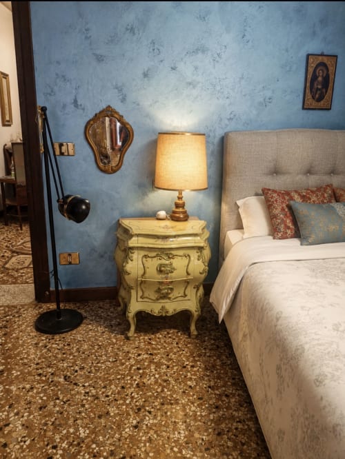 Luxury bedroom at Luxury Loft Venice with blue textured walls, beige headboard bed, yellow side table with lamp