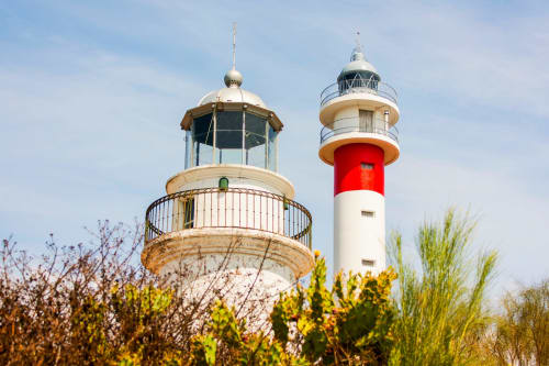 Históricos faros con torre de rayas rojas y blancas cerca del Hotel Plaza Chica en Cartaya, España