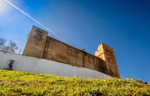 Estructura de fortaleza de piedra histórica en Hotel Plaza Chica en Cartaya bajo cielo azul despejado