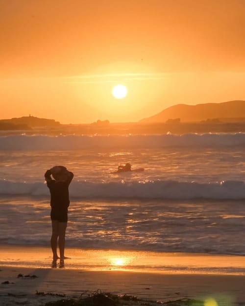 Silhouette regardant le coucher de soleil à la plage de Trévou-Tréguignec, vue côtière à l'heure dorée